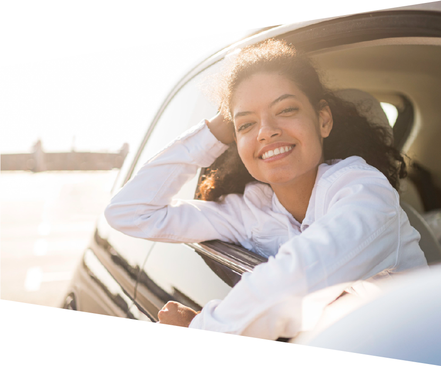 mulher sorrindo pela janela de um carro